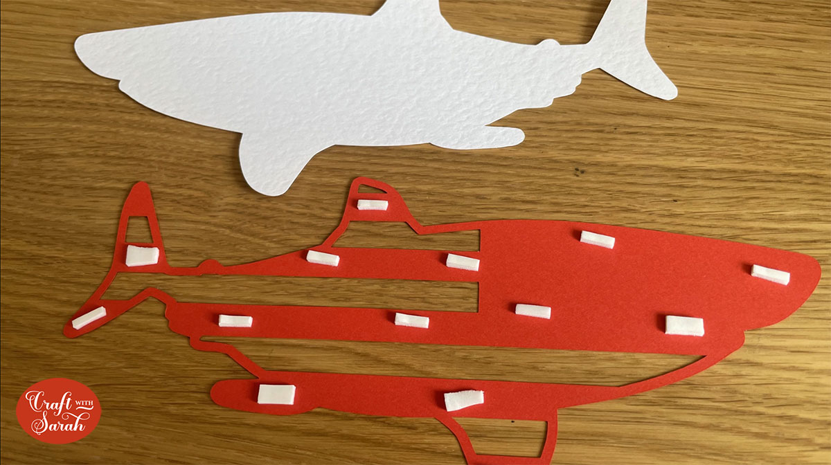 Use foam pads to stick the red layer onto the bottom white layer